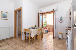 una cucina e una sala da pranzo con tavolo e sedie di Daniela Apartments a Massa