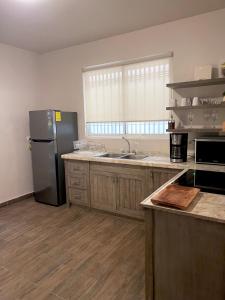 ラパスにあるCasa Divinaの冷蔵庫とシンク付きのキッチン