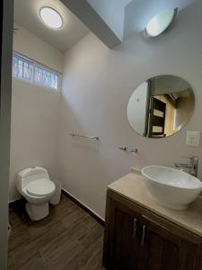 ラパスにあるCasa Divinaのトイレ、洗面台、鏡のあるバスルーム