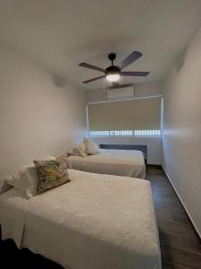 ラパスにあるCasa Divinaのベッド2台と天井ファンのある部屋