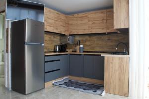 a kitchen with a stainless steel refrigerator and wooden walls at Садиба Кичера Еко in Mizhhirya