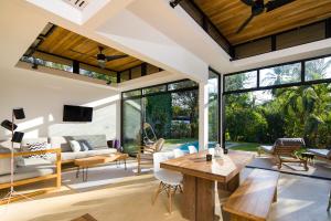 an open living room with a table and chairs at Nalu Nosara Pool Villa Sol in Playa Guiones +2 photos