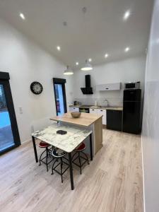 una cucina con un tavolo e sedie in una stanza di L'échapée du Col Bayard a Gap