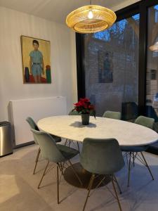 un tavolo da pranzo con sedie e un vaso di fiori di Cièlo a Tongeren