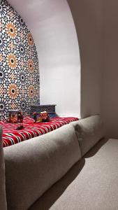 Una habitación con una cama con una pared con un patrón. en Casa Norte, en Tetuán