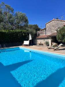 レ・ヴァンにあるPetit mas familial ardéchoisの家の隣の青い大型スイミングプール