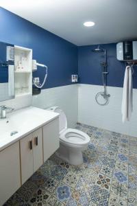 a bathroom with a toilet and a blue wall at The Full Hot Spring & Resort in Kemloko-gede +16 photos