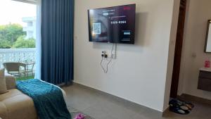 Una sala de estar con un televisor de pantalla plana en la pared. en Arishi cozy haven, en Malindi