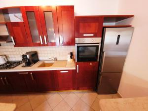 una cucina con mobili in legno e un frigorifero in acciaio inossidabile di Mare a Korčula