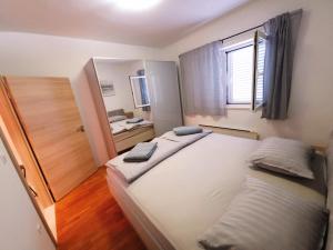 una camera da letto con un grande letto bianco con una finestra di Mare a Korčula