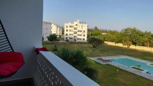 balcón con vistas a la piscina y a los edificios en Arishi cozy haven, en Malindi