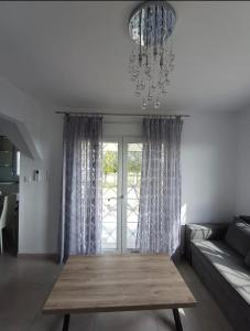 a living room with a table and a chandelier at Mare Resort Maggana in Xanthi