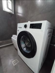 a washing machine sitting next to a toilet in a bathroom at Mare Resort Maggana in Xanthi