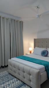 Un dormitorio con una cama grande con cabecero capitoné. en Arishi cozy haven, en Malindi 30 fotos más
