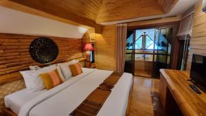 a bedroom with a large white bed with a television at Sunset Park Resort and Spa By SWR in Na Jomtien