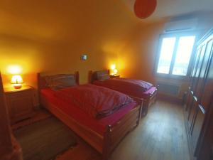 two beds in a room with two lamps and a window at Room Algo in Algolsheim