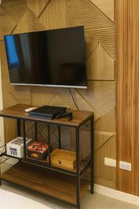 New Studio Boho Studio with PS4 & Balcony في سان فيرناندو: تلفزيون بشاشة مسطحة على طاولة في الغرفة