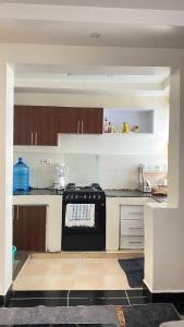 ThikaSunrise apartment next to bullys hotel的厨房配有黑炉灶烤箱