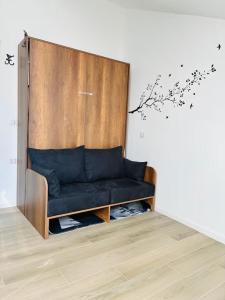 a black couch sitting in a room with a wall at Urban Nest in Milan