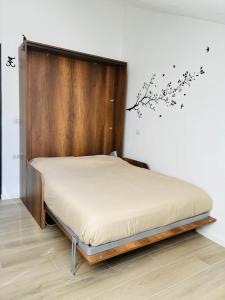 a bed with a wooden headboard in a room at Urban Nest in Milan