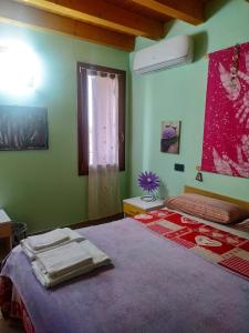 a bedroom with green walls and a bed with towels on it at Il Tempo Dei Sogni in San Benedetto Po