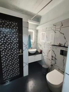 a bathroom with a white toilet and a sink at Thiramizhi in Ernakulam