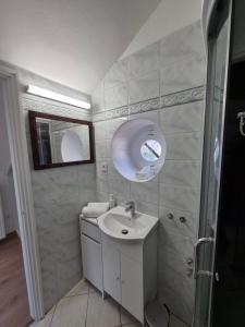 un baño con lavabo y espejo en Red Lion Pub & Apartments Szentendre, en Szentendre