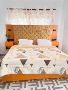 a bedroom with a large bed with a wooden headboard at AnKeS Lodge in Kontrajeso