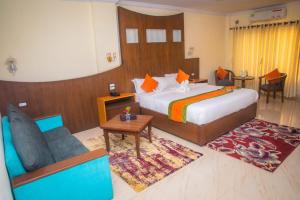 a hotel room with a bed and a couch at Gautam Buddha International Hotel Ltd in Gautam Buddha International Airport