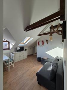 Una sala de estar con un sofá y un comedor. en Red Lion Pub & Apartments Szentendre, en Szentendre