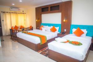 a bedroom with two beds with orange and blue at Gautam Buddha International Hotel Ltd in Gautam Buddha International Airport