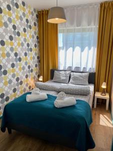 een slaapkamer met 2 handdoeken op een bed met een raam bij Apartamenty Czerwone Korale in Chłopy