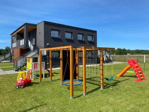 a playground with play equipment in a yard at Apartamenty Czerwone Korale in Chłopy