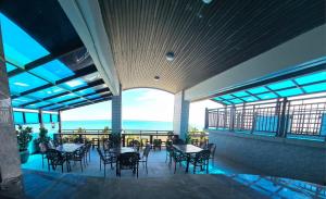 The Caye Hotel Caye Caulker في كاي كولكر: مطعم مع طاولات وكراسي وإطلالة على المحيط