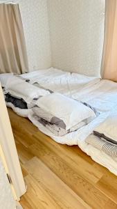 two unmade beds sitting on a wooden floor at aiki home in Tokyo