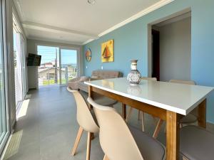 Apê Alegria - Capri Morada & Mar - Frente mar في ساو فرانسيسكو دو سول: غرفة طعام بها طاولة وكراسي