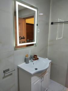 Apartments Sunny في بيشيشي: حمام أبيض مع حوض ومرآة +8 صور