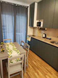 Apartments Sunny في بيشيشي: مطبخ وغرفة طعام مع طاولة وكراسي