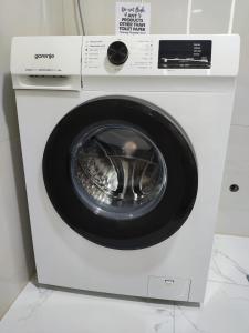 Apartments Sunny في بيشيشي: وجود غسالة ملابس بيضاء في الغرفة