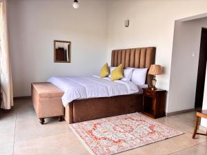 Nest Villas في سري جايواردنيبورا كوته: غرفة نوم بها سرير كبير مع عثماني وسجادة +6 صور