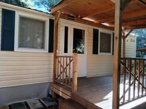 een veranda aan de voorzijde van een huis met een houten terras bij Glamour Pakoštane Mobile Home in Pakoštane