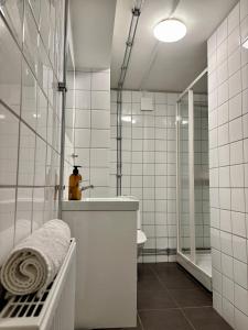 a white bathroom with a sink and a shower at Sundsvall By M - Basement Studio in Sundsvall +20 photos