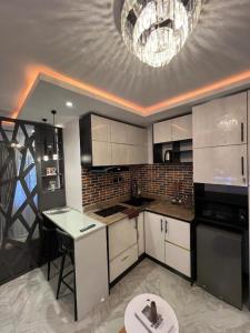 ラゴスにあるHertz Studioの白いキャビネットとシャンデリア付きのキッチン
