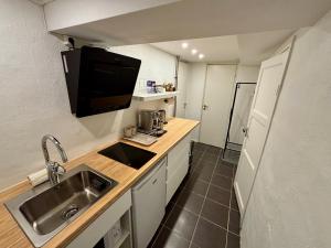 a small kitchen with a sink and a microwave at Sundsvall By M - Basement Studio in Sundsvall +7 photos