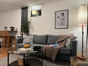a living room with a couch and a table at Sundsvall By M - Basement Studio in Sundsvall