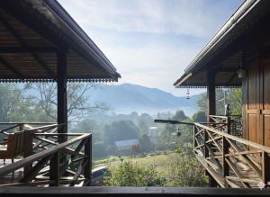 une vue depuis le porche d'une maison avec des montagnes en arrière-plan dans l'établissement Camelliana Horizon Pongyang, à Mae Rim