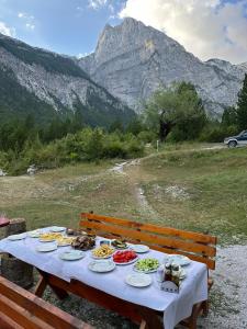 Kulla e gjyshit- Guest House في ثيث: طاولة عليها صحون طعام مع جبل