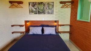 a bedroom with a blue bed with two white pillows at Suite na Natureza com Café da Manhã in São Pedro