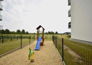 a playground with a slide in front of a building at Leśna Przystań Rumia - obok Gdyni i Aquaparku Reda in Rumia