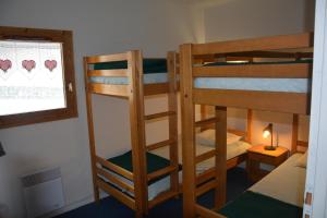 a room with two bunk beds and a window at l'Antre du Cerf in Villarodin-Bourget